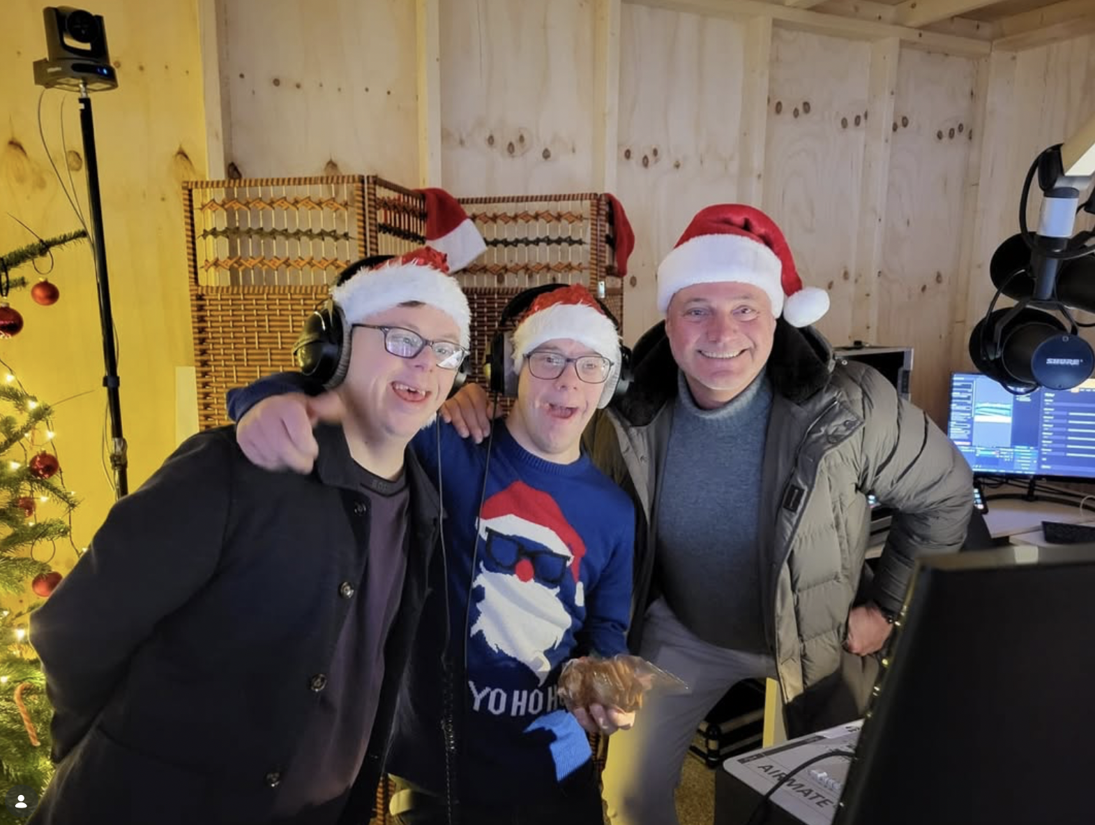 Presentatoren met kerstmutsen in de radiostudio van het Glazen Huis