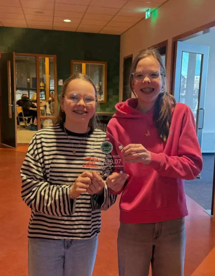 Twee leerlingen met een glazen award van het Glazen Huis