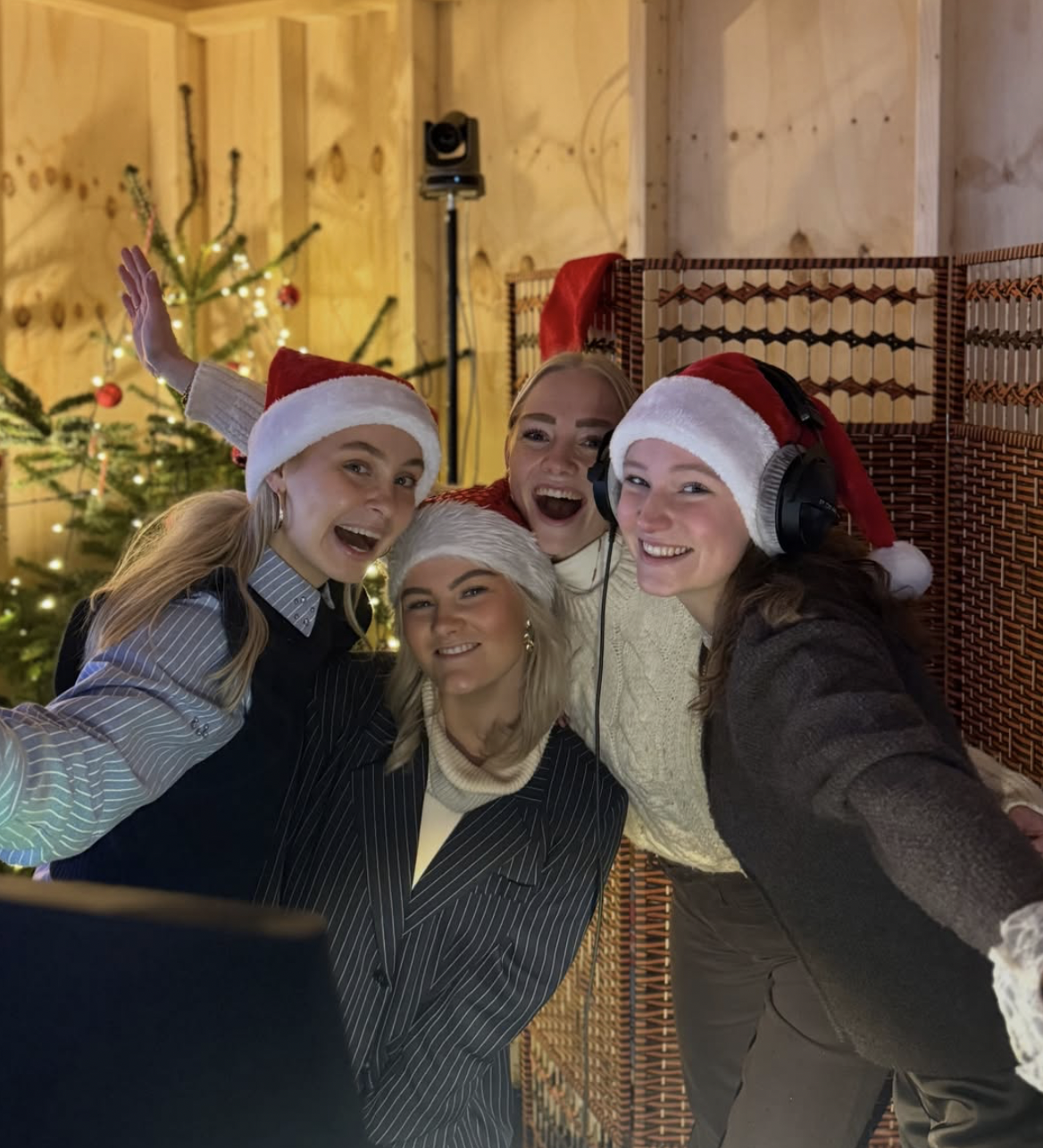 Vier presentatrices met kerstmutsen in de studio